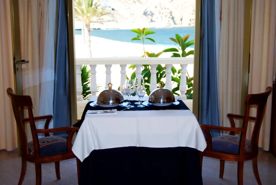 Mesa de desayuno junto a un ventanal con vistas al mar