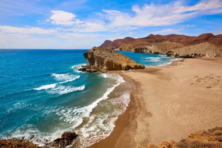 Playa de arena entre acantilados volcánicos en Cabo de Gata