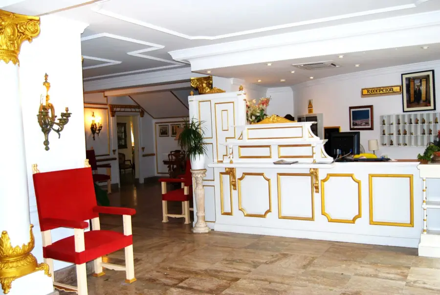 Recepción del hotel con sillas rojas y detalles dorados